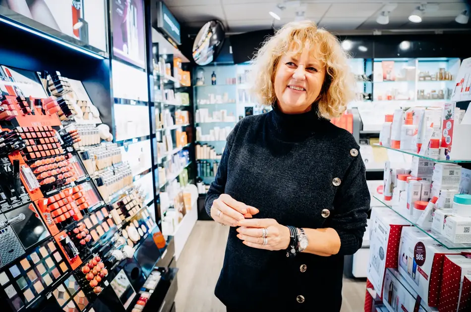 ansatt viser frem ulike sminkeprodukter