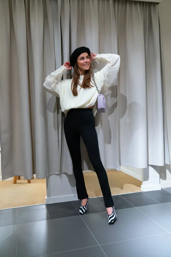 Nina Sandbech på H&M i hvit genser, sort bukse og lilla veske