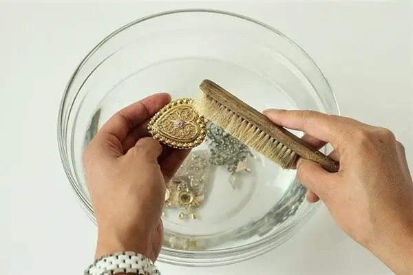 Bunadssølv som blir pusset med børste