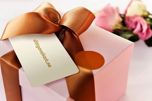 dittgavekort som ligger på en gave med blomstrer i bakgrunnen