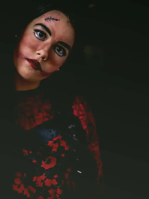 Dame i mørkt rom med skummel sminke