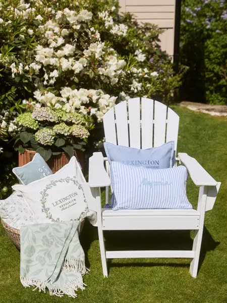 Lexington interiørtekstiler ute ved hagestol i grønn hage med blomster