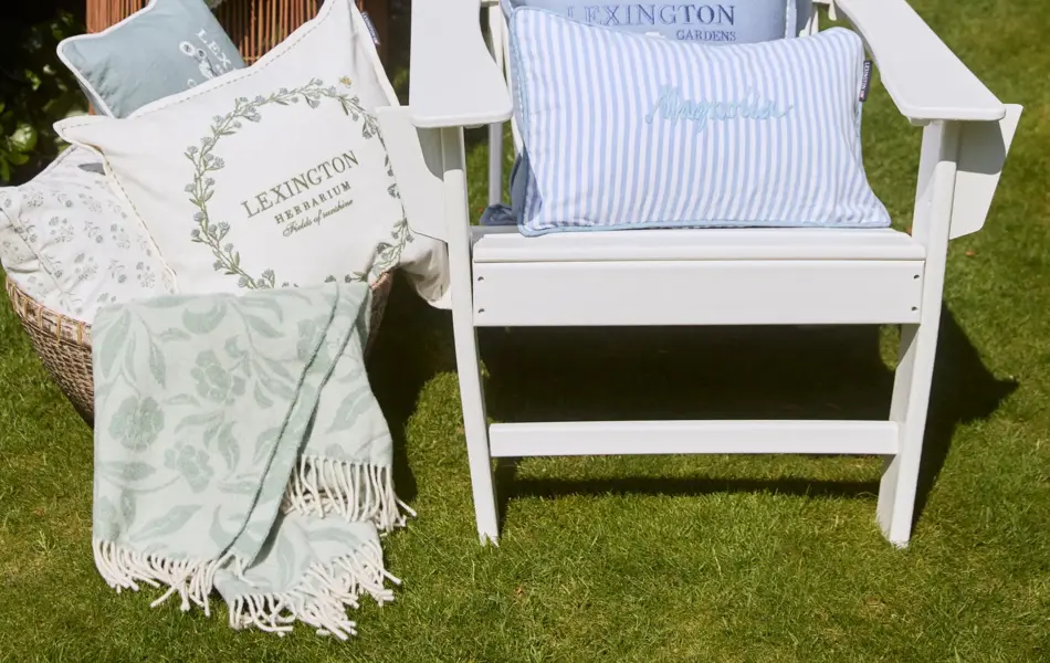 Lexington interiørtekstiler ute ved hagestol i grønn hage med blomster