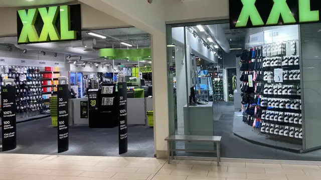 innendørs butikk med sport og store grønne skilter