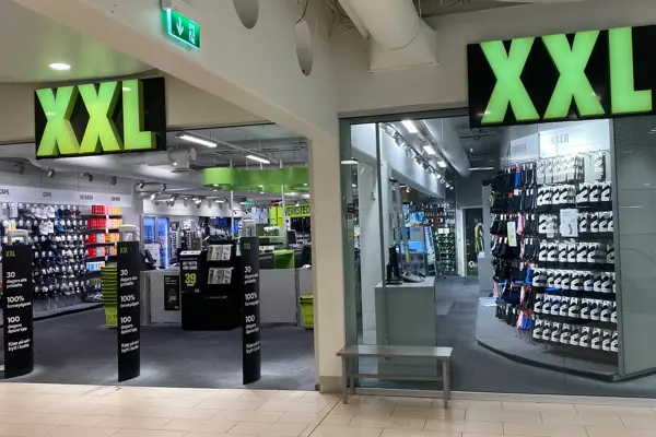 innendørs butikk med sport og store grønne skilter
