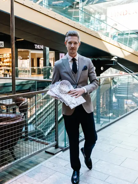 mann i dress holder skjorter