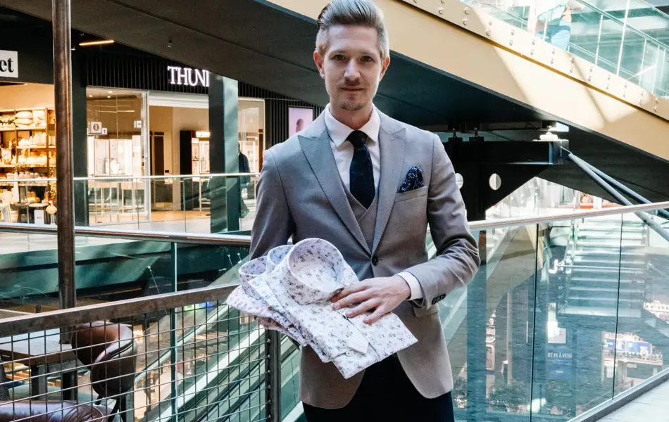 mann i dress holder skjorter