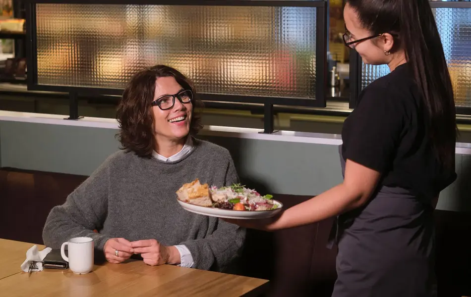 dame får servert mat hos jordbærpikene