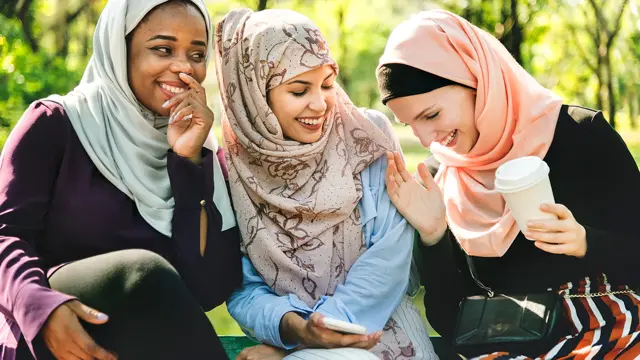 Damer som sitter sammen og smiler