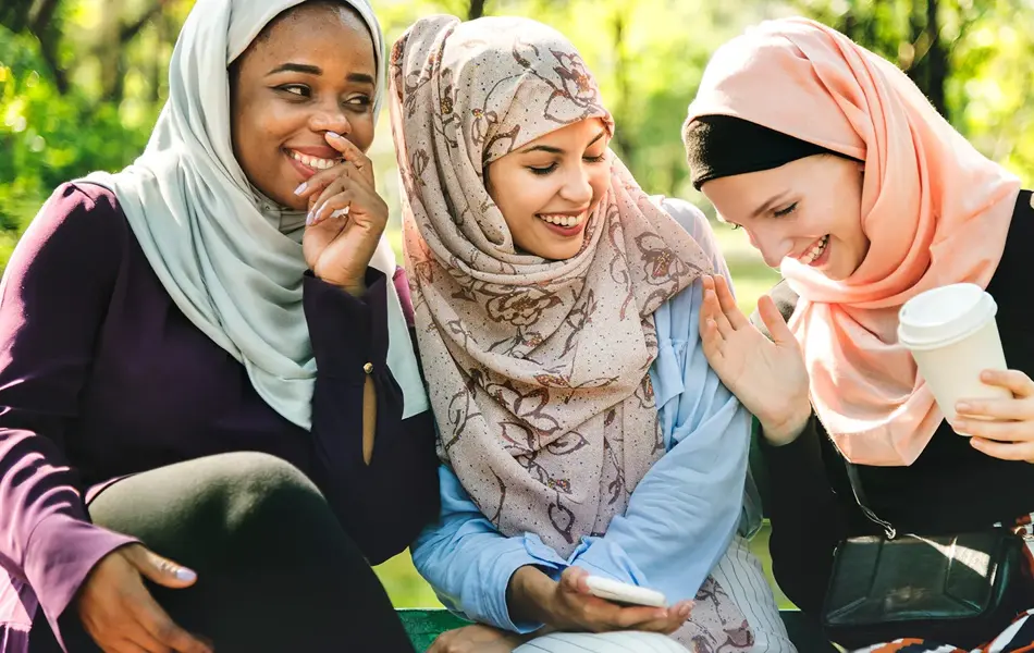 Damer som sitter sammen og smiler