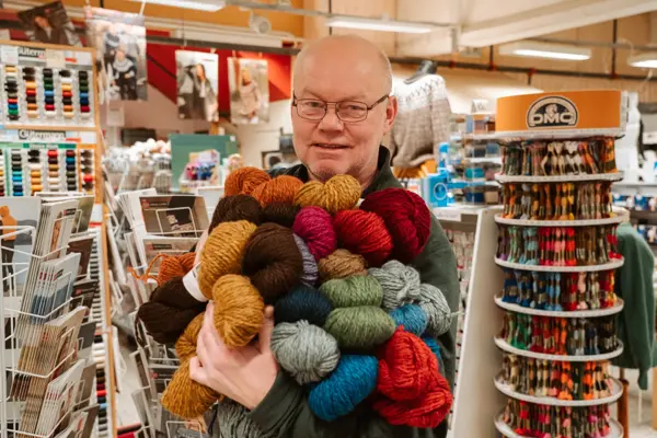 ansatt viser frem utvalg av garn