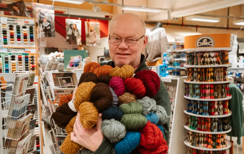 ansatt viser frem utvalg av garn
