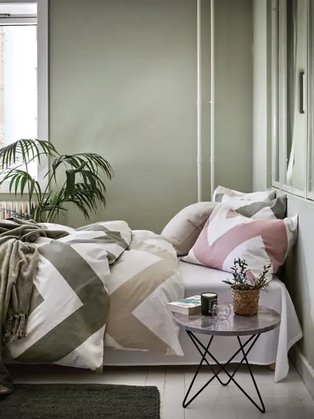 Seng med sikksakk mønster sengesett med grønne vegger 