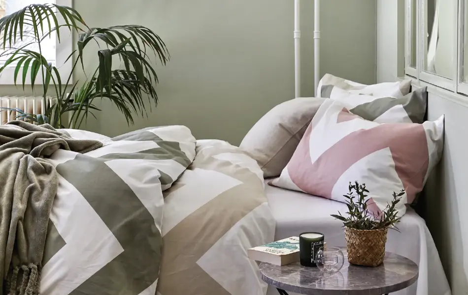 Seng med sikksakk mønster sengesett med grønne vegger 