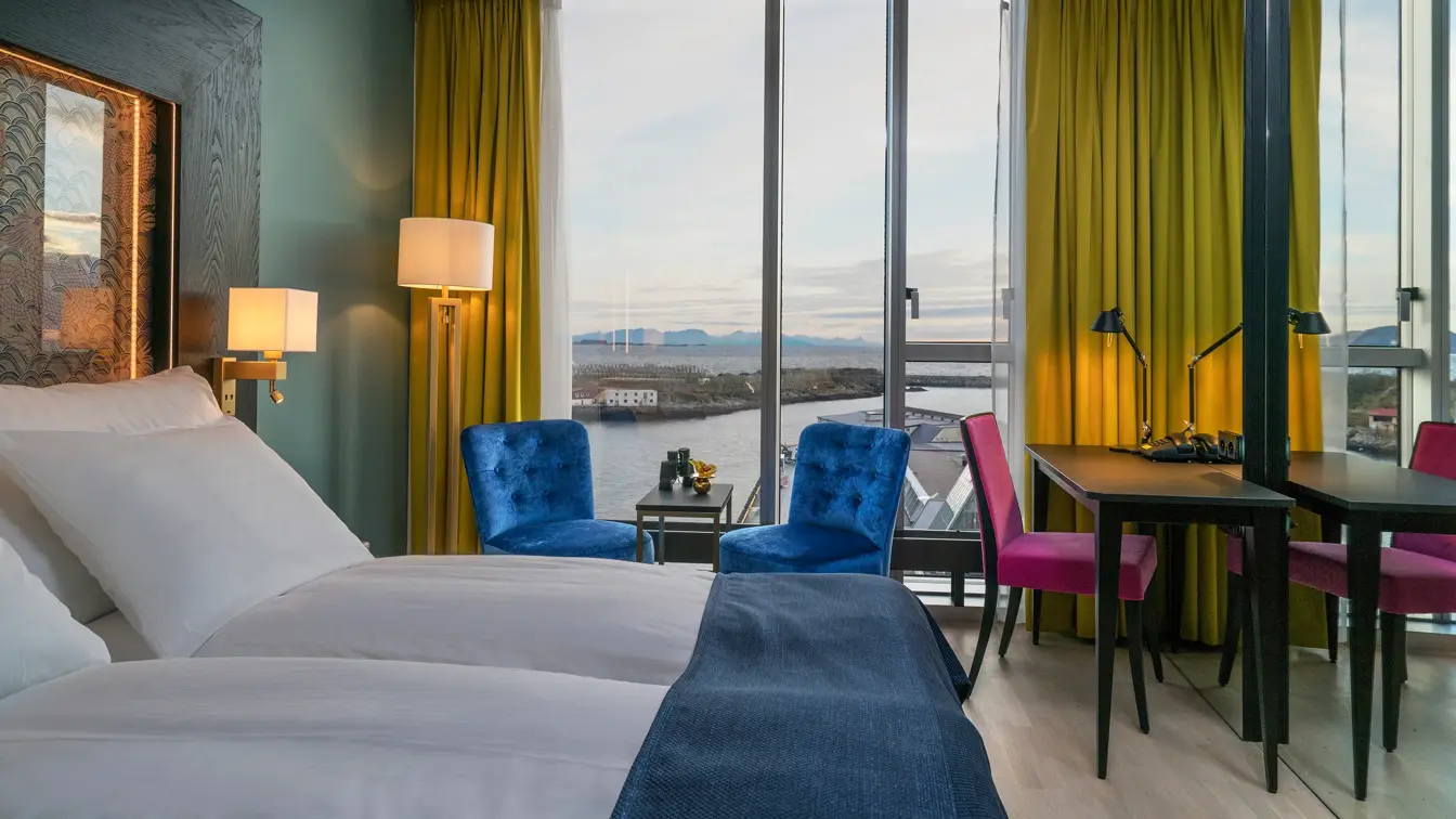 to stoler, dobbeltseng og skrivepult med utsikt på Superior room på Thon hotel Lofoten i Svolvær