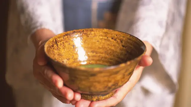 Kvinne holder fram en keramikkskål