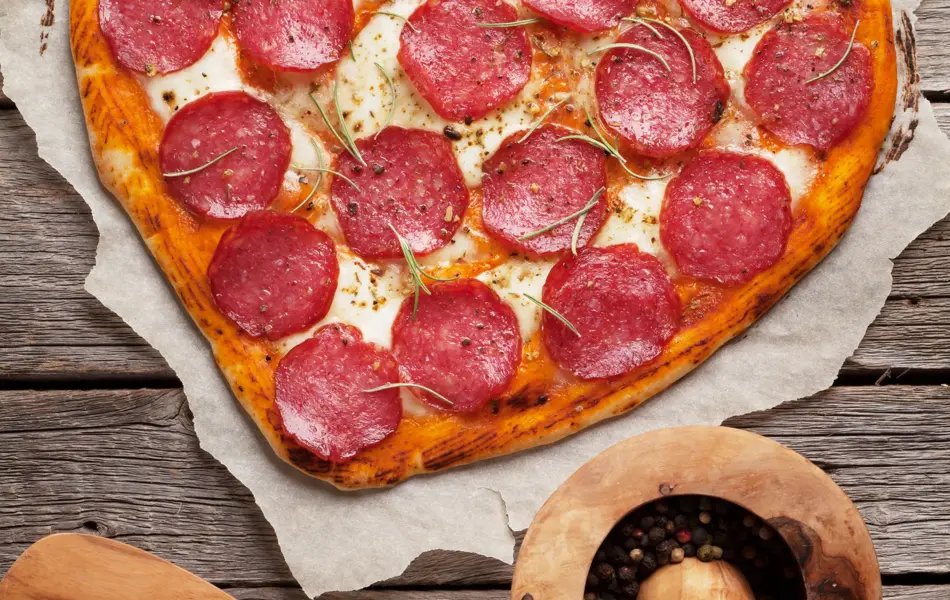Heart shaped pizza with pepperoni and mozzarella. Valentines day greeting card. Top view