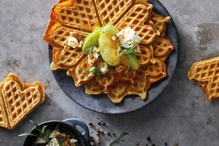Vafler på grå tallerken, topping av pære, krem og urter