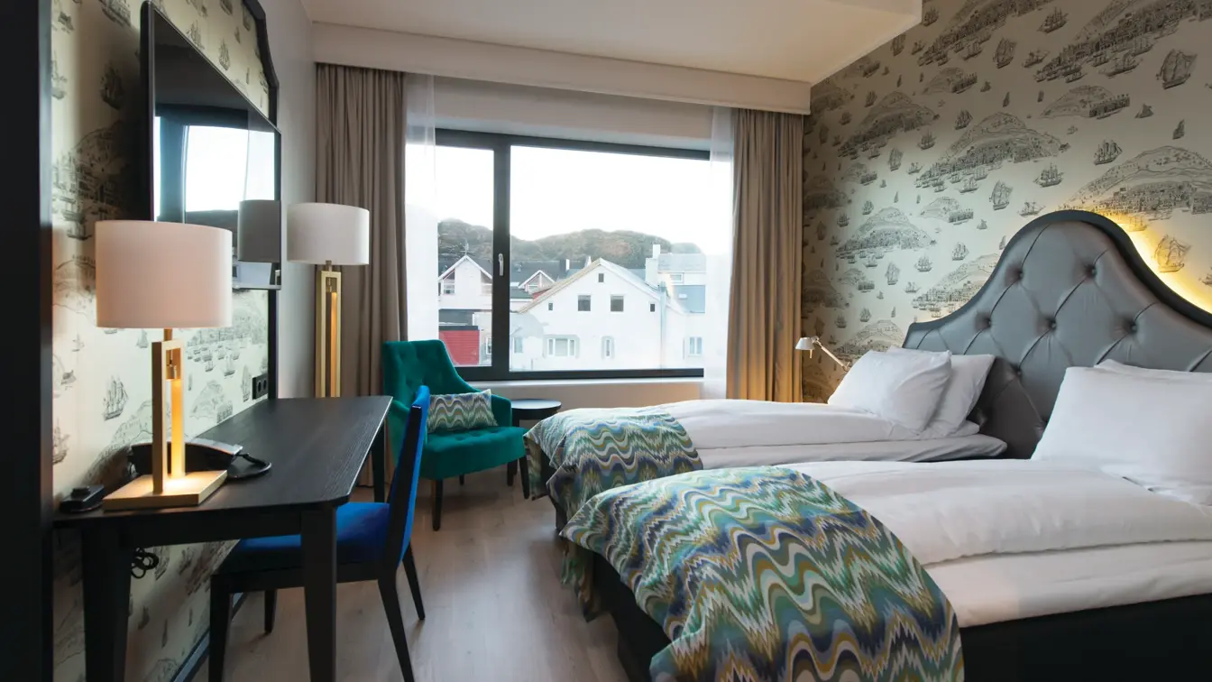 Twinseng, arbeidspult og stol på twinrom på Thon Hotel Fosnavåg med utsikt utover havet