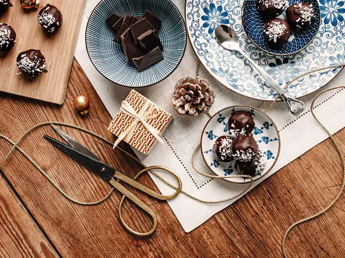 Bord sett ovenfra som er dekket med konfekt og innpakningspapir. Foto.