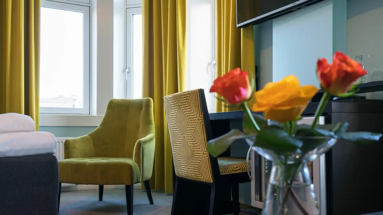 Stol og vas med roser i familierom på Thon Hotel Nidaros