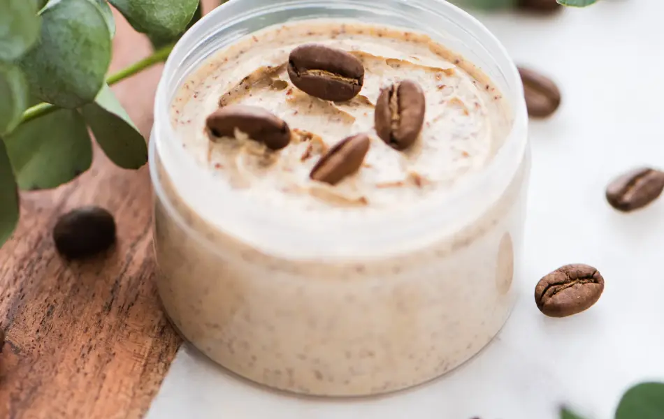 Natural body coffee scrub with eucalyptus branches on marble background. Cosmetic product or face cream container. Flat lay, top view