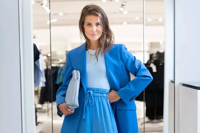 Ung kvinne kledd i blå dress fra topp til tå