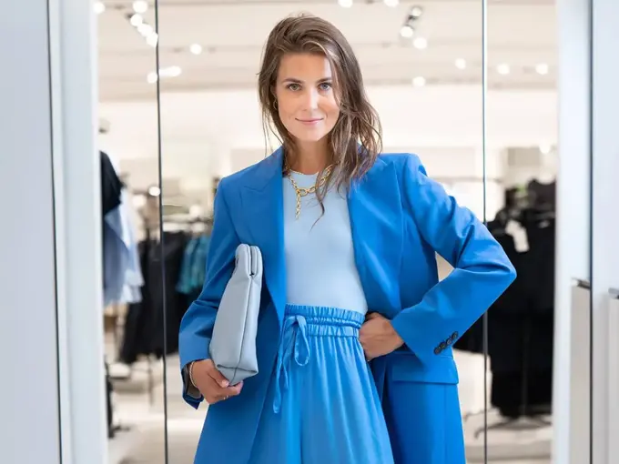 Ung kvinne kledd i blå dress fra topp til tå