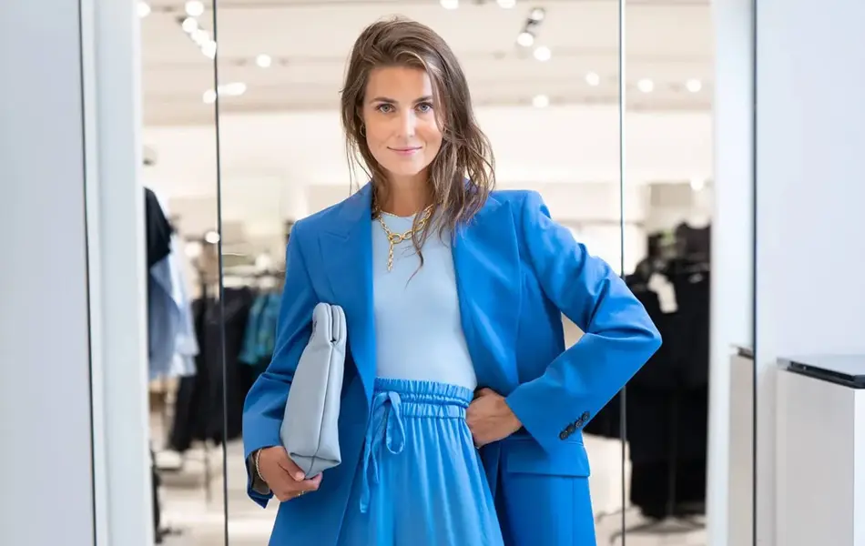 Ung kvinne kledd i blå dress fra topp til tå