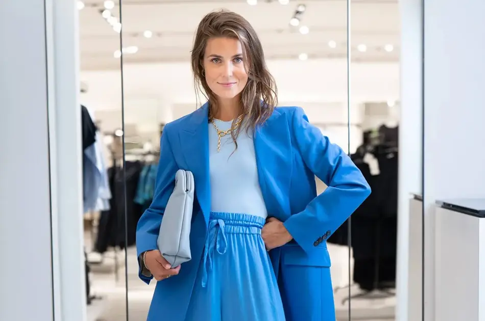 Ung kvinne kledd i blå dress fra topp til tå