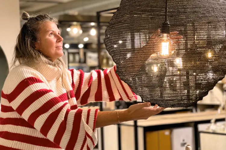 Dame viser frem lampe