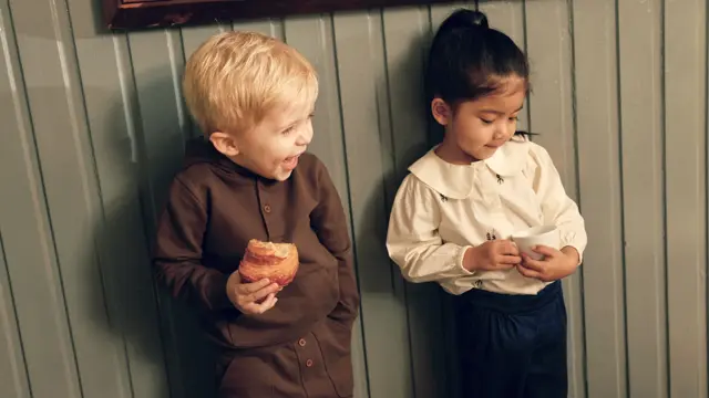 Barn som lener seg på en vegg