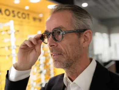 Geir Krogh holder seg på brillen og ser til siden.