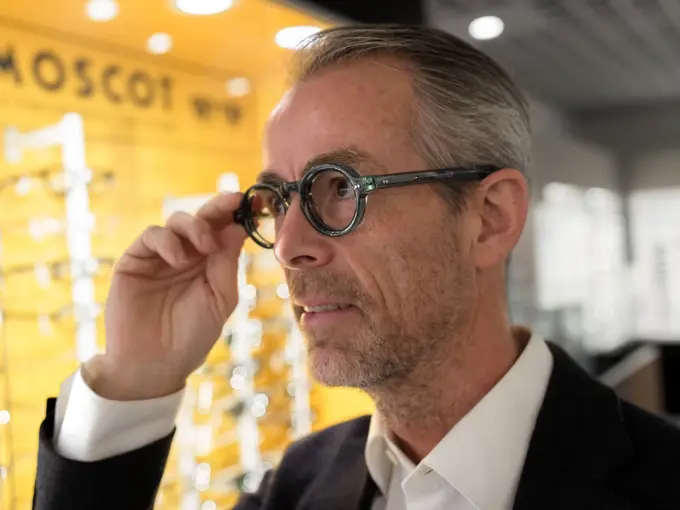 Geir Krogh holder seg på brillen og ser til siden.