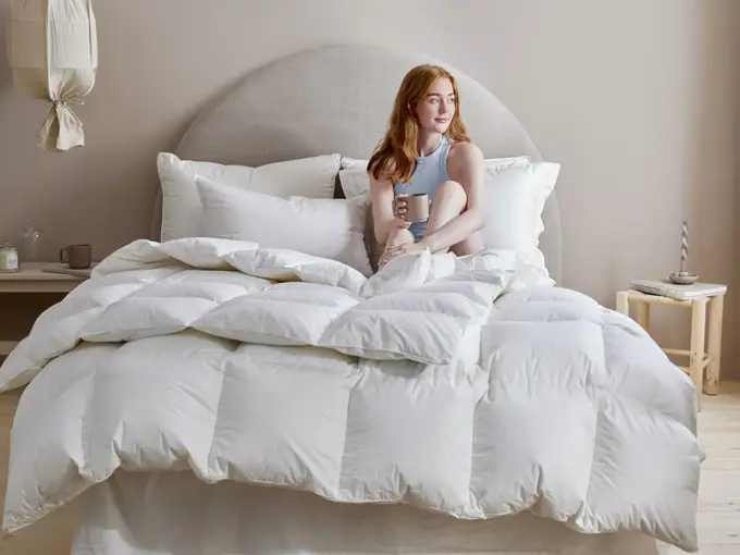 Dame som sitter i en seng