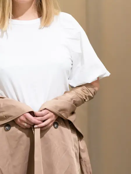 Vårens trender vist av en jente med halvlangt blondt hår. Rosa, 90 tallet og trenchcoat er en del av vårens trender