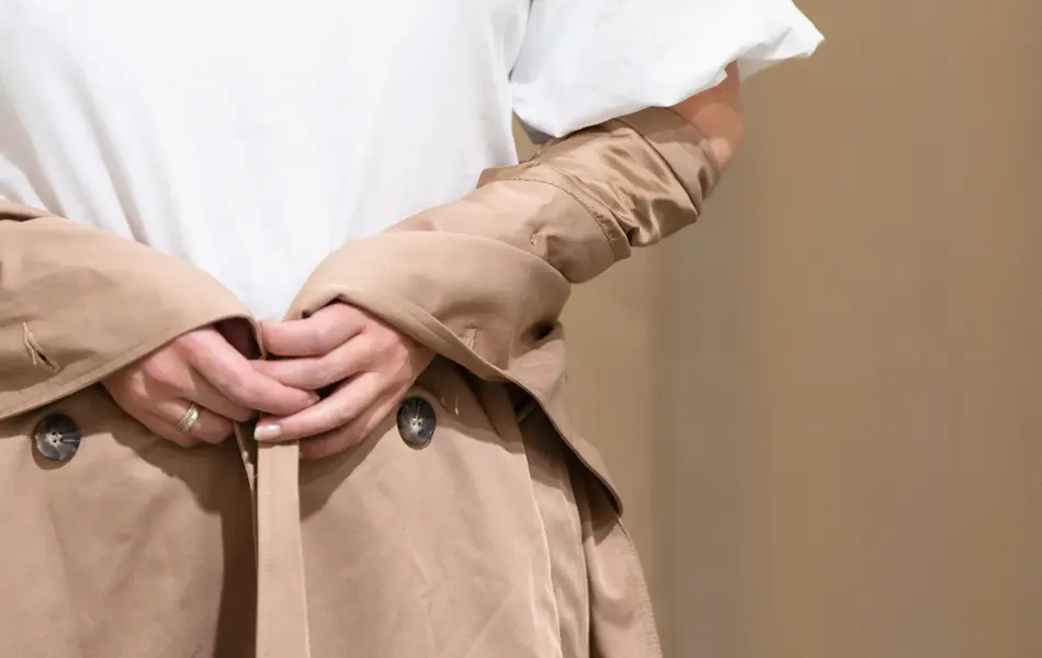 Vårens trender vist av en jente med halvlangt blondt hår. Rosa, 90 tallet og trenchcoat er en del av vårens trender