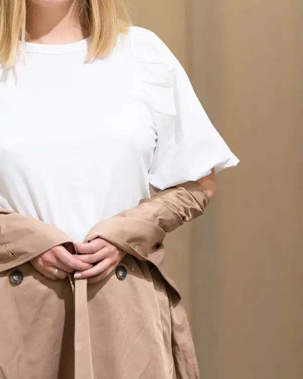 Vårens trender vist av en jente med halvlangt blondt hår. Rosa, 90 tallet og trenchcoat er en del av vårens trender