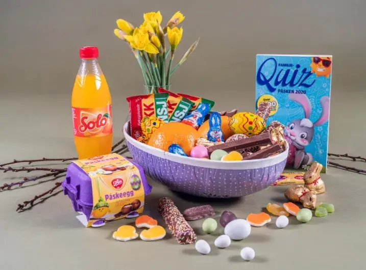 Et halvt påskeegg med appelsin og påskesjokolade, en påskequiz ved siden av og en halv liter med orange Solo i en brusflaske. 