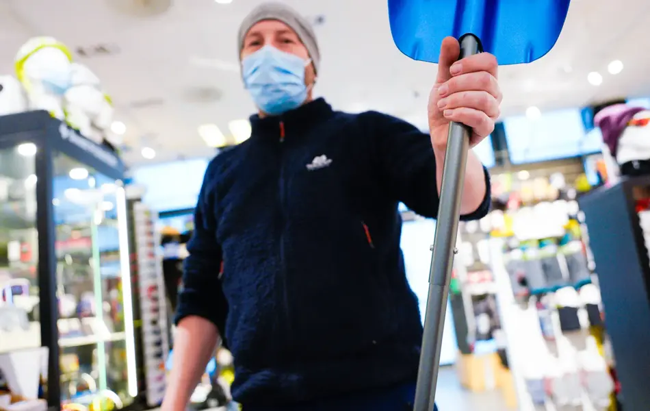 Jente med orangesekk og blådunjakke, og langrennski og slalåmski