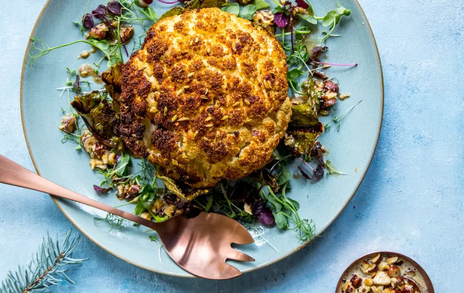 Blomkålstek dandert på en blå tallerken