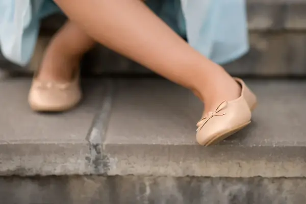 Nærbilde av beige ballerinasko med sløyfe  