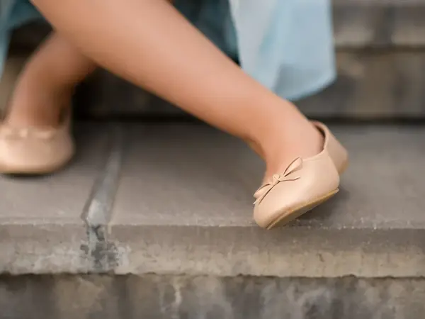 Nærbilde av beige ballerinasko med sløyfe  