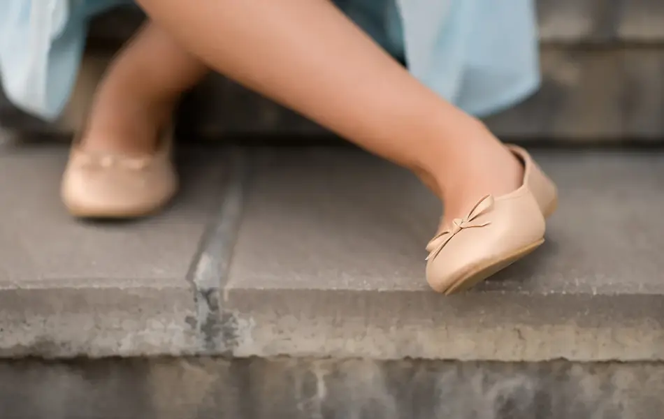 Nærbilde av beige ballerinasko med sløyfe  