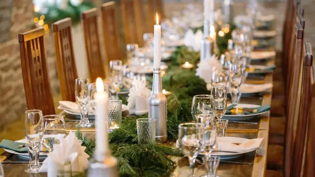 nature, winter, table setting concept. among clean plates, sparkling glasses, candle holders and other silverware there is lots of fresh and aromatic branches of some fur tree