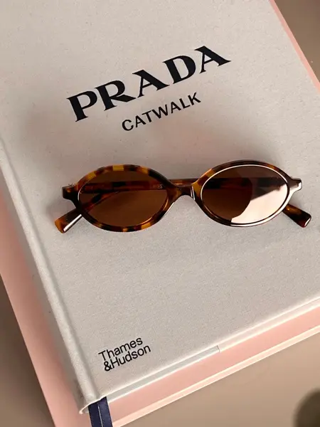 Solbriller som ligger på en bok om Prada