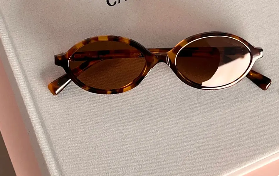 Solbriller som ligger på en bok om Prada