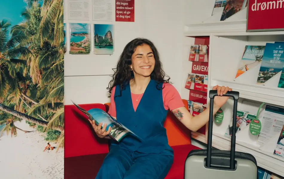 Jente på reisebyrå med koffert