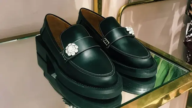 Nærbilde av skinnmokasiner i gullhylle