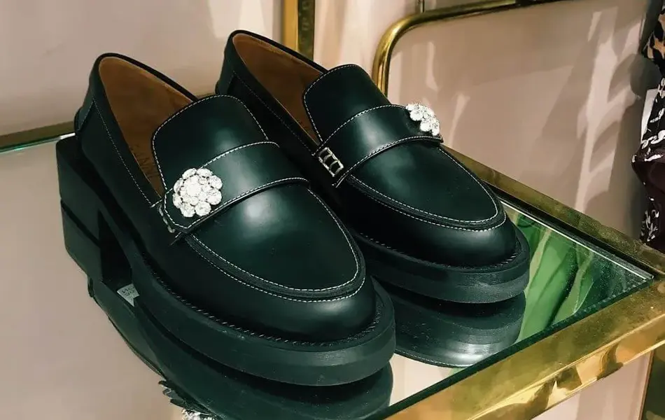 Nærbilde av skinnmokasiner i gullhylle